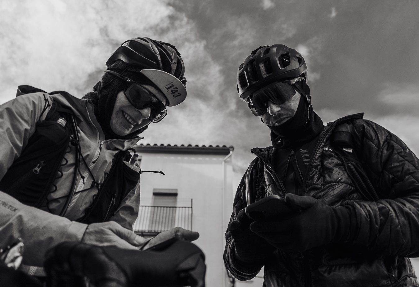 Two riders checking the coordinates of the next checkpoint on their phones